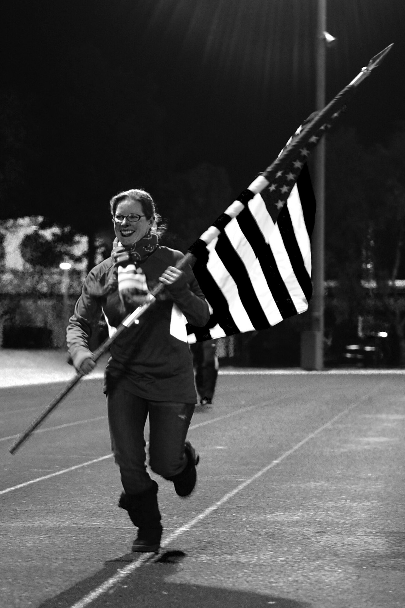 A Royal Air Force Lakenheath, England, community member runs with the U.S. flag during the 24-hour Veterans Day vigil run at the RAF Lakenheath track Nov. 14, 2013. Airmen from the 48th Fighter Wing ran laps in honor of fallen and current veterans. (U.S. Air Force photo by Airman 1st Class Dawn M. Weber)     