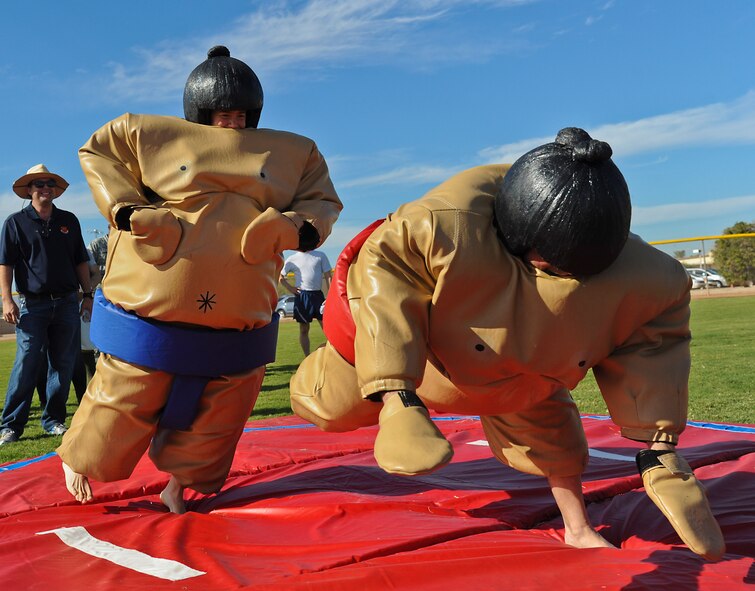 Lt. Col. Stephane Wolfgeher, 309th Fighter Squadron commander, knocks down Maj. Raymond Chester Jr., 56th Communications Squadron commander, during the sumo wrestling sports day competition. The 309th FS placed first in the sumo wrestling competition. (U.S. Air Force photo/Staff Sgt. Darlene Seltmann)