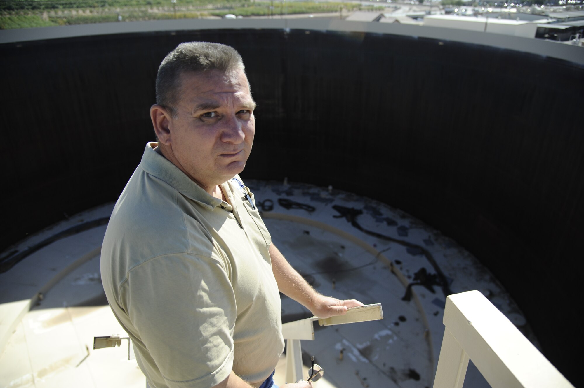 Ed Smith, 56th Logistics Readiness Squadron fuels terminal superintendent, stands above a fuel tank under renovation Oct. 21 at Luke Air Force Base. This JP-8 jet fuel tank is the largest at Luke and was built in the 1940s. (U.S. Air Force photo/Staff Sgt. Luther Mitchell Jr.)