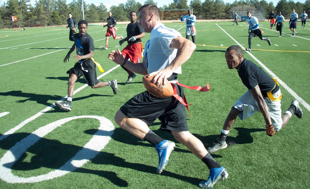 131109-F-GZ967-095 2nd Lt. Brian Lindsay, USAFA Prep School assistant football coach, rushes past Airman 1st Class Devin Harris, 90th Maintenance Operations Squadron, as he attempts to get a first down in the Rocky Mountain Regional Military Flag Football Championship game Nov. 9 at the academy. Lindsay was the quarterback for the academy team. (U.S. Air Force photo by Airman 1st Class Brandon Valle)