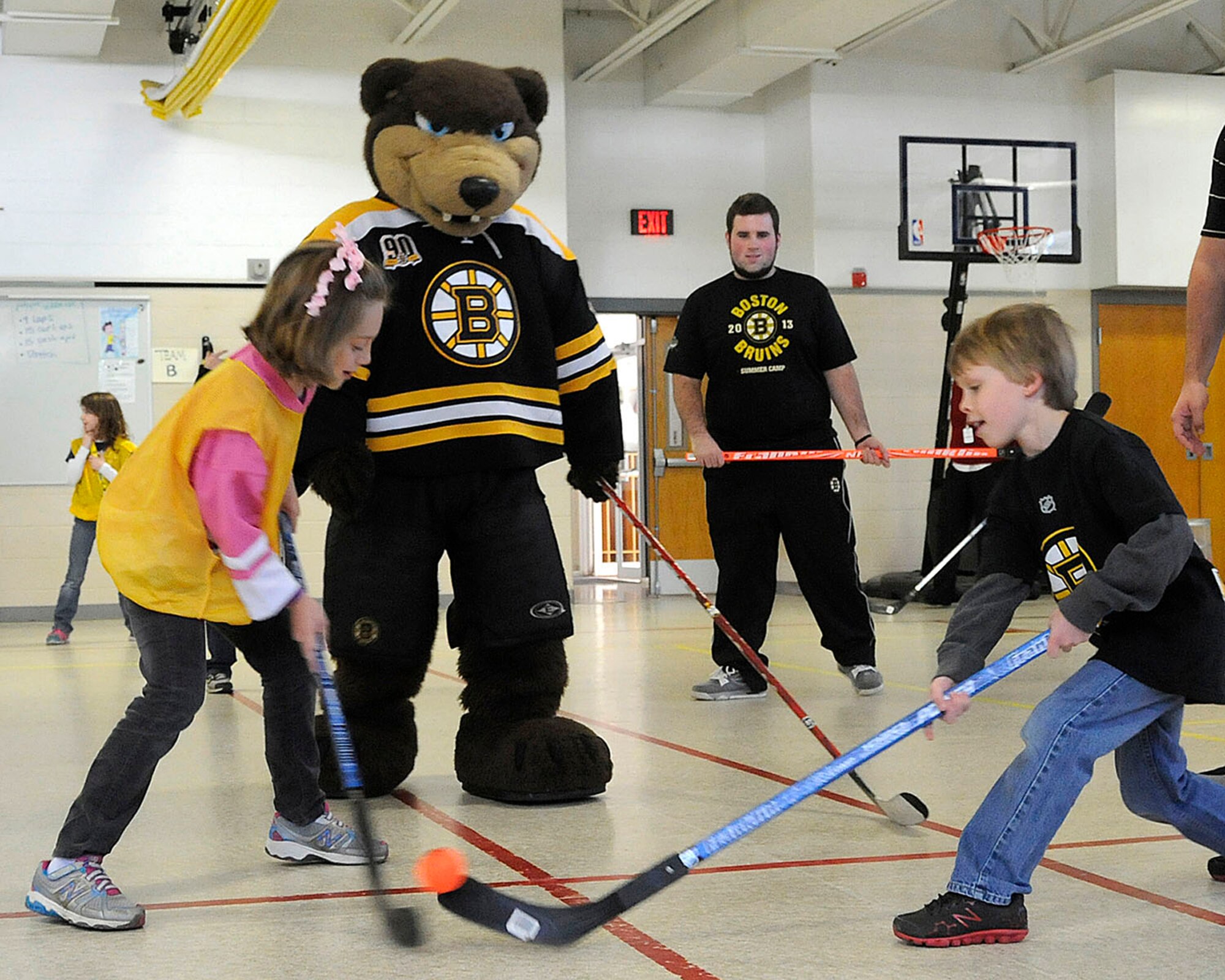 HANSCOM AIR FORCE BASE, Mass. - Boston Bruins mascot Blades looks on as Emma Morales (left) and Joseph Carey face off during a visit by members of the Boston Bruins to the Hanscom Primary School Nov. 13. Bruins staff led children through a number of hockey drills focusing on the fundamentals of play. (U.S. Air Force photo by Linda LaBonte Britt)