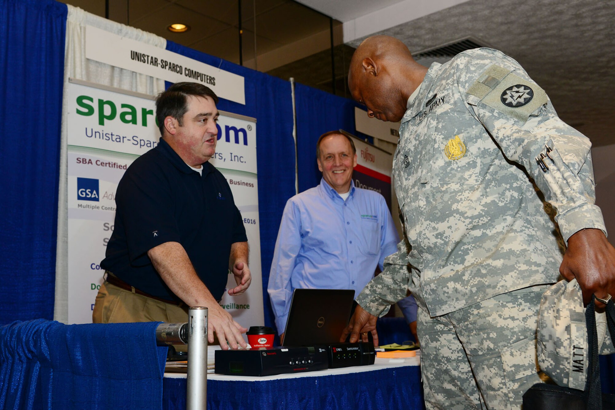 From left, Seth Foley, Emerson Network Power account manager, and Mark Miller, Unistar-Sparco account manager, explain the uses of a keyboard, video and mouse switch to U.S. Army Sgt. Maj. Michael Matt, 93rd Signal Brigade transitioning operations sergeant major of training, during a technology exposition at Fort Eustis, Va., Nov. 14, 2013. The companies presented the KVM switches to military and government personnel as part of the three-day expo, visiting Langley Air Force Base, Fort Eustis and Naval Weapons Station Yorktown. (U.S. Air Force photo by Staff Sgt. Ashley Hawkins/Released) (No federal endorsement of vendors implied)
