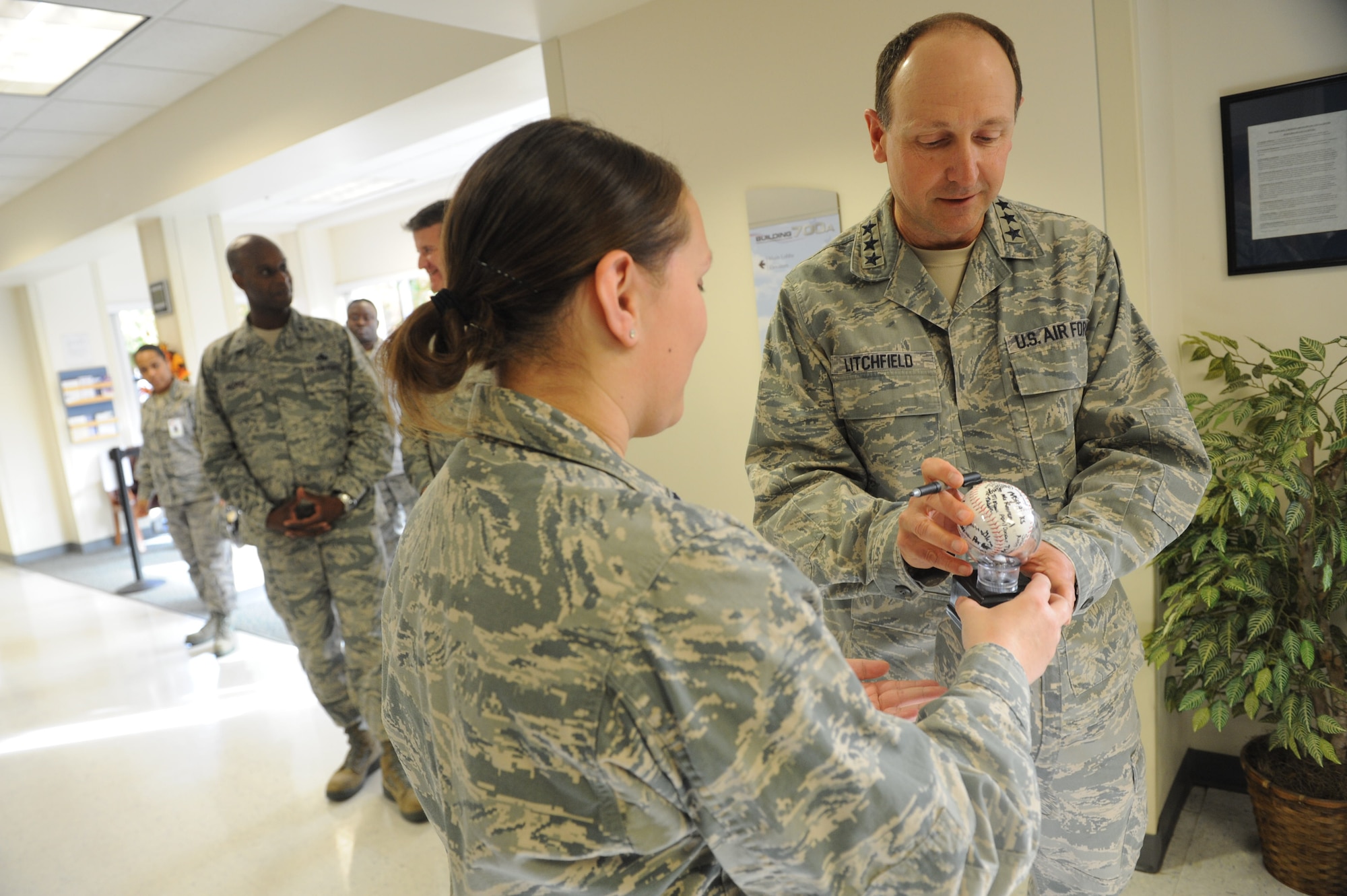 Lt. Gen. Bruce Litchfield, Air Force Sustainment Center commander, signs the ball of one of the 78th MDG’s Super Teams. (U.S. Air Force photo by Tommie Horton)