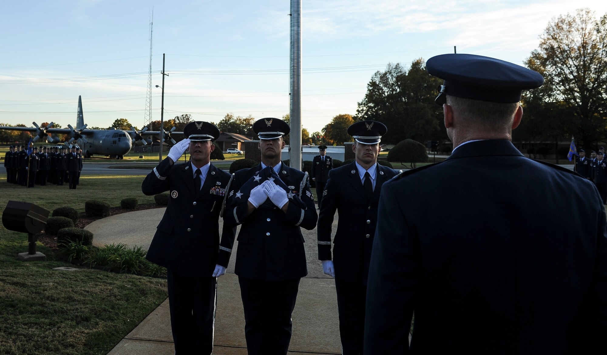 A Little Rock Air Force Base ceremonial guardsman salutes Col. Patrick Rhatigan, 19th Airlift Wing commander, as the flag is retired during the Veterans Day Retreat Ceremony Nov. 8, 2013, at LIttle Rock Air Force Base, Ark. Veterans Day is observed Nov. 11 and was originally known as Armistice Day or Remembrance Day. (U.S. Air Force photo by Staff Sgt. Jake Barreiro) 