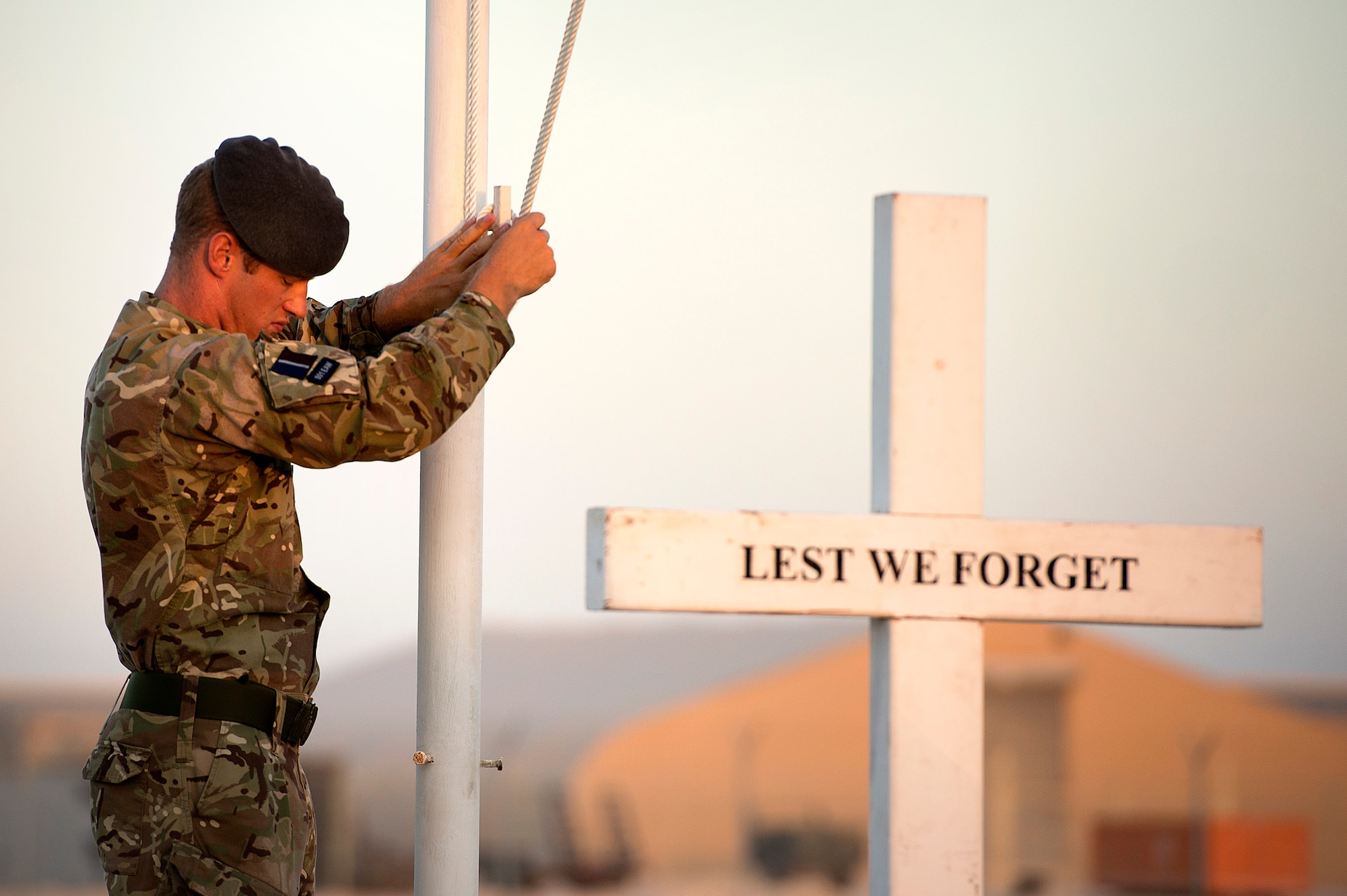 Royal Air Force Cpl. Olie Dunk pauses while lowering the English Union Flag during a sunset remembrance ceremony at the 83rd Expeditionary Air Group headquarters Nov. 9, 2013. The RAF's 83 EAG is responsible for all English units operating in Afghanistan and the Middle East. (USAF Photo by Master Sgt. Ben Bloker)