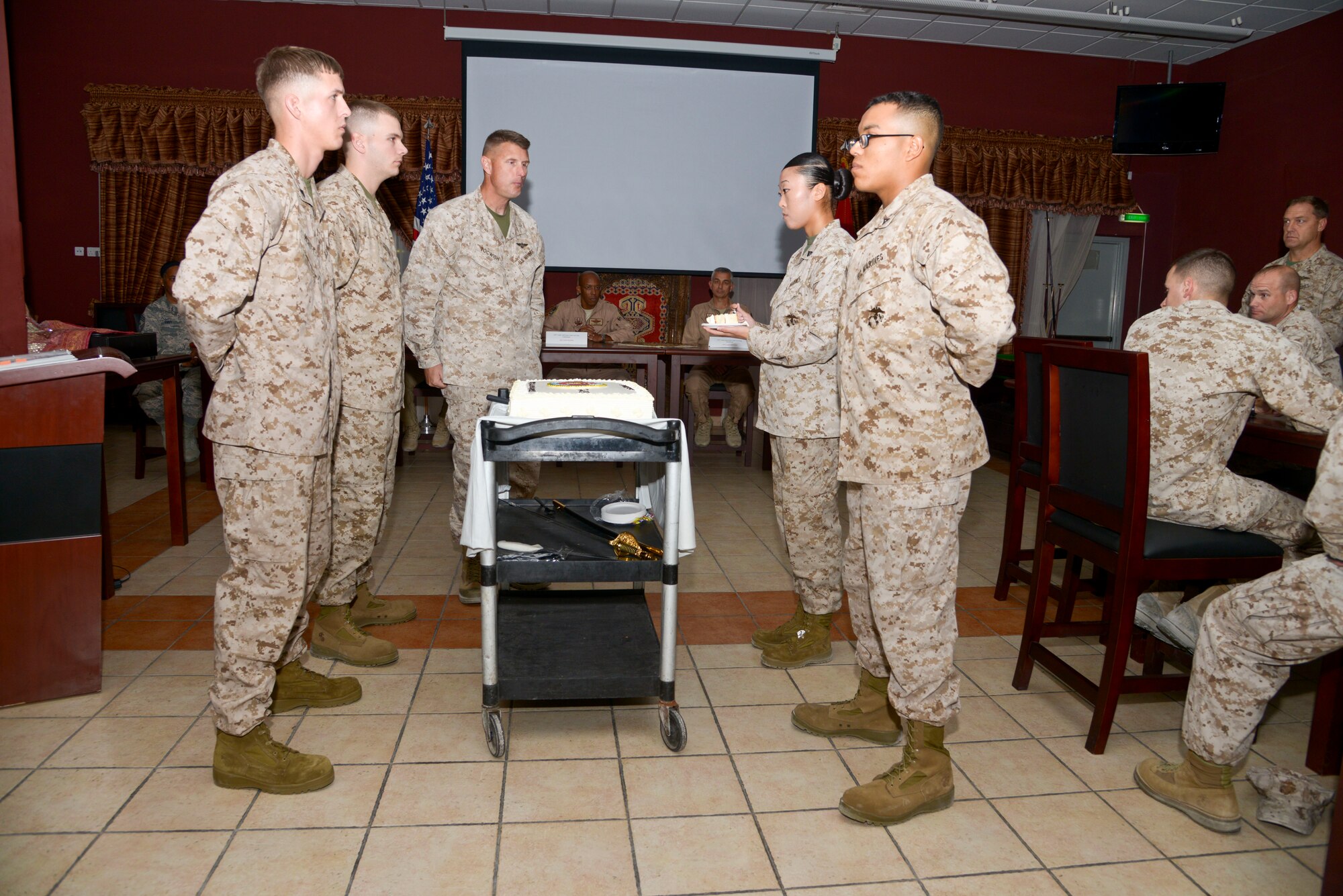 Cpl. Ji Lee takes the second slice of cake during the U.S. Marine Corps 238th birthday cake cutting ceremony at the 379th Air Expeditionary Wing in Southwest Asia, Nov. 10, 2013. It is customary for Marines to cut a birthday cake during the ceremony.  The passing of cake from the oldest Marine to the youngest symbolizes the passing history and tradition from the outgoing generation of Marines to the incoming.  Lee is deployed from Headquarters Group, II Marine Expeditionary Force, Camp Lejeune, N.C., and hails from Torrance, Calif. (U.S. Air Force photo/Tech. Sgt. Joselito Aribuabo)