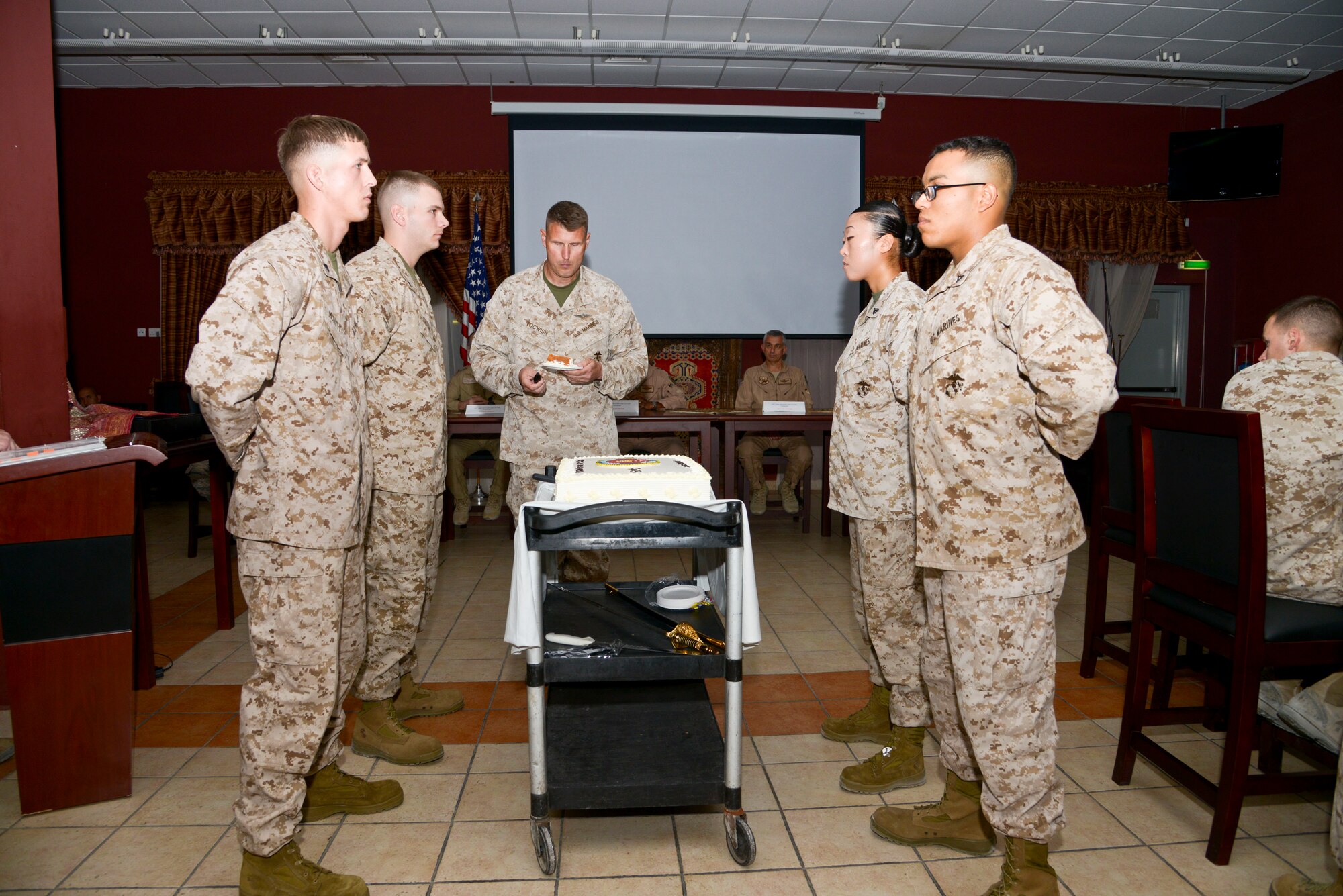 Col. Timothy Tocwish takes the first slice of cake during the Marine Corps 238th Birthday cake cutting ceremony at the 379th Air Expeditionary Wing in Southwest Asia, Nov. 10, 2013. The passing of cake from the oldest Marine to the youngest symbolizes the passing history and tradition from the outgoing generation of Marines to the incoming.  Tocwish is with U.S. Marine Corps Central Command deployed from Marine Air Control Group 48, Great Lakes, Ill., and hails from Joliet, Ill. (U.S. Air Force photo/Tech. Sgt. Joselito Aribuabo)