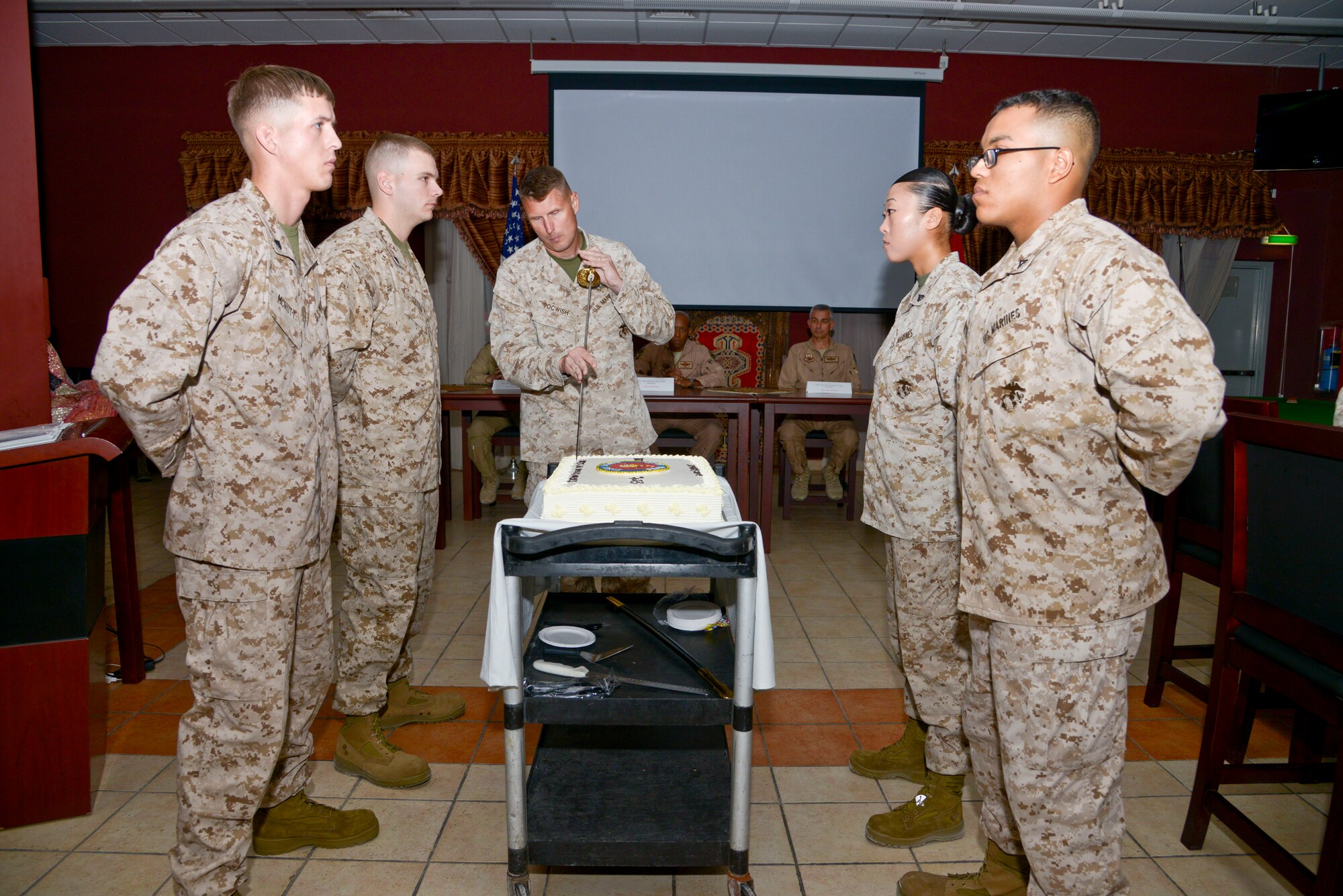 Col. Timothy Tocwish cuts the cake during the Marine Corps 238th Birthday cake cutting ceremony at the 379th Air Expeditionary Wing in Southwest Asia, Nov. 10, 2013. The passing of cake from the oldest Marine to the youngest symbolizes the passing history and tradition from the outgoing generation of Marines to the incoming.  Tocwish is with U.S. Marine Corps Central Command deployed from Marine Air Control Group 48, Great Lakes, Ill., and hails from Joliet, Ill. (U.S. Air Force photo/Tech. Sgt. Joselito Aribuabo)