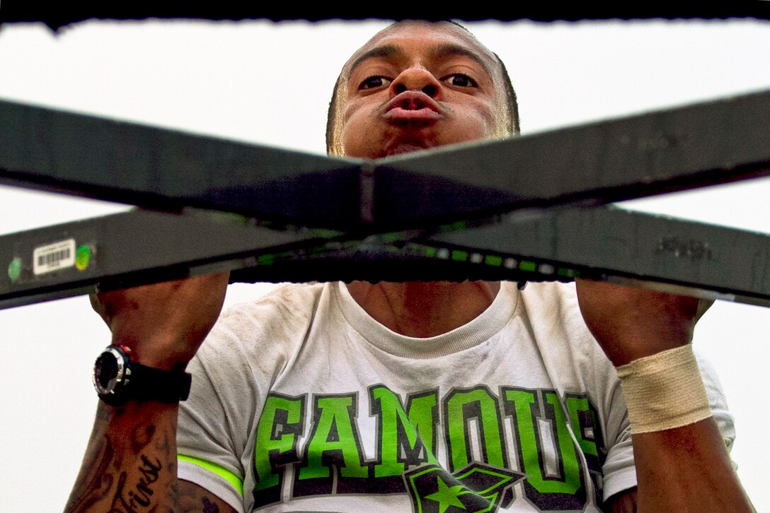 U.S. Army Sgt. Deandre Dabney just clears the bar during a best warrior team challenge on Camp Arifjan, Kuwait, Nov. 11, 2013. Dabney and his partner finished first in the challenge, which included a  sand bag run, 30 pullups, 35 burpees, a wheelbarrel race and a 100-yard sprint. 