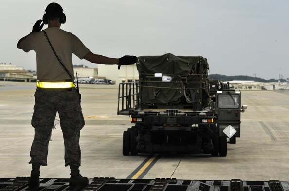 Staff Sgt. Christopher Fleury guides a cargo truck to a C- 17 Globemaster III from Joint Base Pearl Harbor-Hickam, Hawaii, on Kadena Air Base, Japan, Nov. 15, 2013. Water purifiers and military personnel are being sent to the Philippines to help the locals after the devastation caused by Super Typhoon Haiyan. Fleury is a 733rd Air Mobility Squadron air freight supervisor. (U.S. Air Force photo/Senior Airman Marcus Morris) 