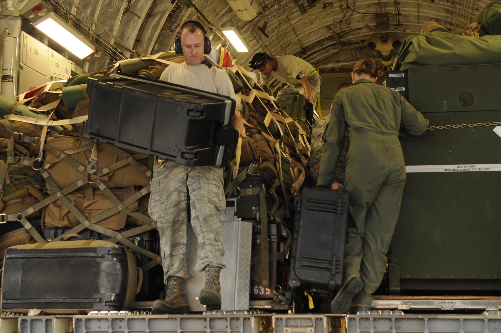 Airmen from the 733rd Air Mobility Squadron load supplies onto a C- 17 Globemaster III from Joint Base Pearl Harbor-Hickam, Hawaii, on Kadena Air Base, Japan, Nov. 15, 2013. Water purifiers and military personnel are being sent to the Philippines to help the locals after the devastation caused by Super Typhoon Haiyan. (U.S. Air Force photo/Senior Airman Marcus Morris) 