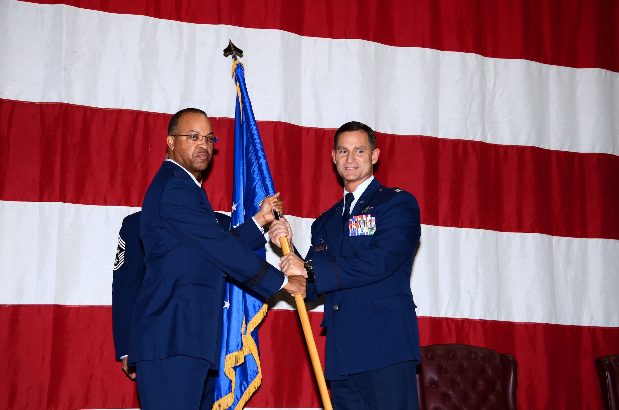 Col. Brett Clark, 94th Airlift Wing commander, takes the wing colors from Brig. Gen. Curtis Williams, 22 Air Force vice commander, during an Assumption of Command ceremony Nov. 15 on Dobbins Air Reserve Base. Clark has been to Dobbins Air Reserve Base before, serving as the 94th Operations Group commander for a short time. (U.S. Air Force photo/Brad Fallin)