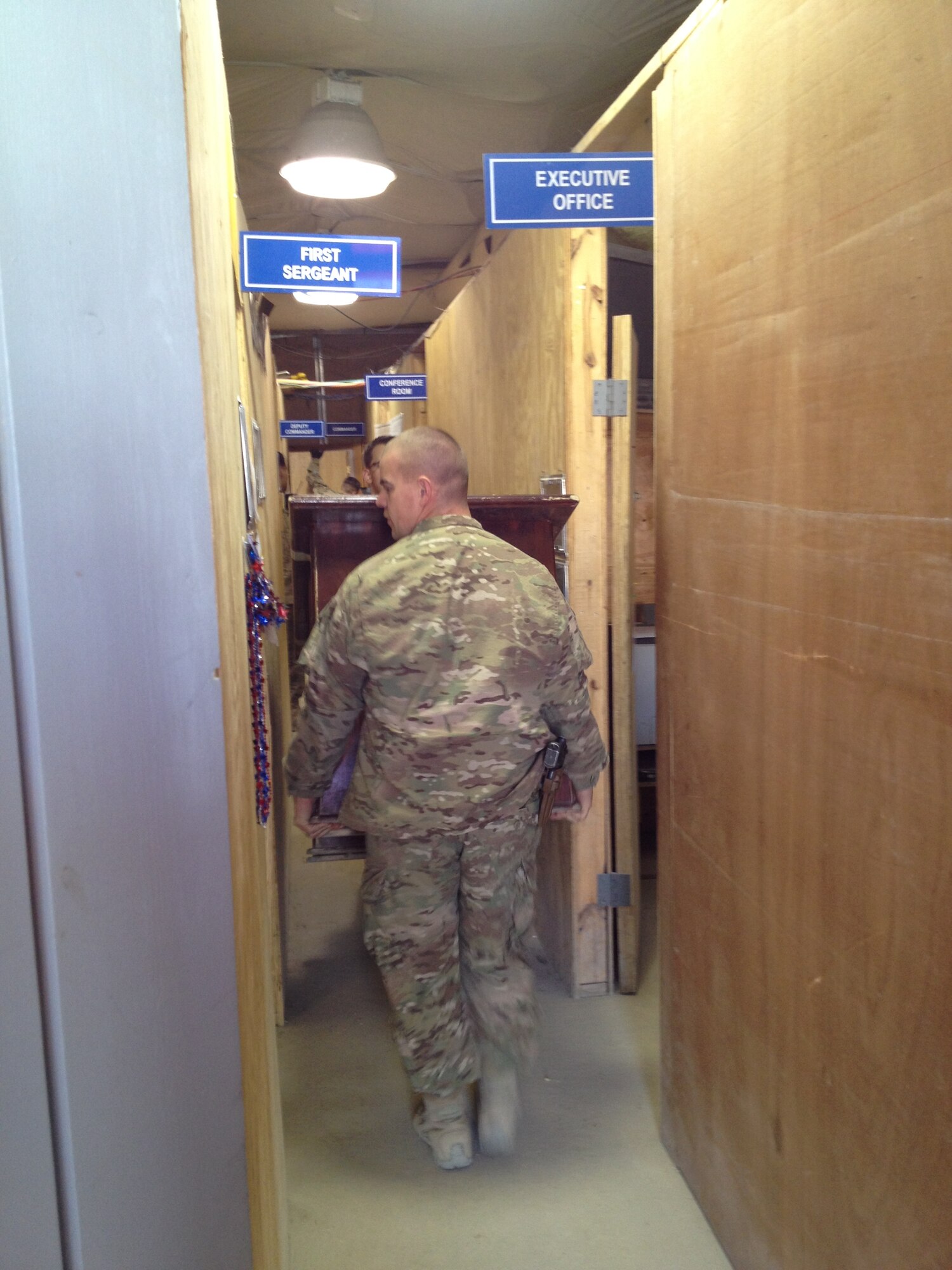 Capt. Josh McCullion, 455th Expeditionary Mission Support Group executive officer, deployed from Vandenberg Air Force Base, Calif., and a native of Summit Hill, Pa., helps move his office on Bagram Airfield, Afghanistan, Nov. 15, 2013. The 455 EMSG staff recently relocated from an expeditionary tent in Camp Cunningham to a new hardened facility here next to the old Russian control tower. (U.S. Air Force photo/Staff Sgt. Lorika Howe)