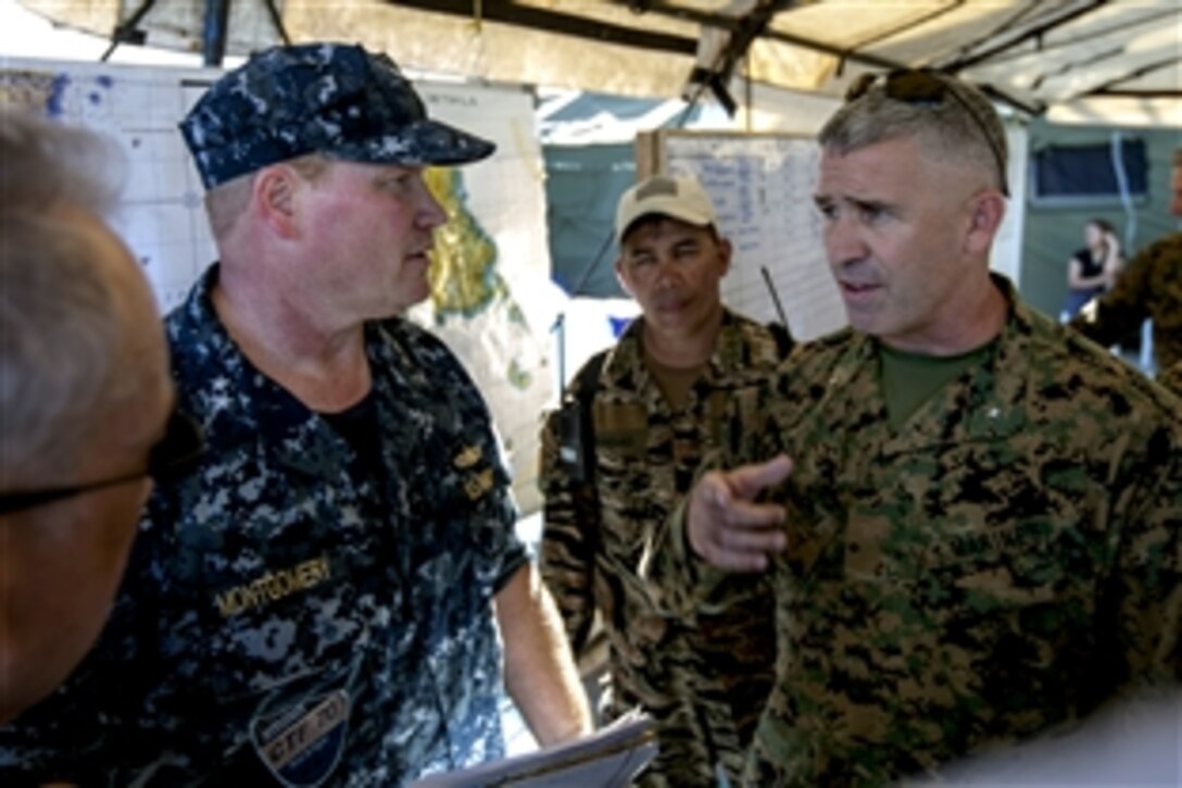 U.S. Marine Corps Brig. Gen. Paul J. Kennedy, right, commanding general of 3rd Marine Expeditionary Brigade, speaks with U.S. Navy Rear Adm. Mark C. Montgomery, commander of Battle Force 7th Fleet and Task Force 70, about ongoing relief operations at the Tacloban Air Field in the Philippines, Nov. 15, 2013. The 3rd Marine Expeditionary Brigade is supporting Operation Damayan, providing humanitarian aid and disaster relief to areas affected by Typhoon Haiyan. 