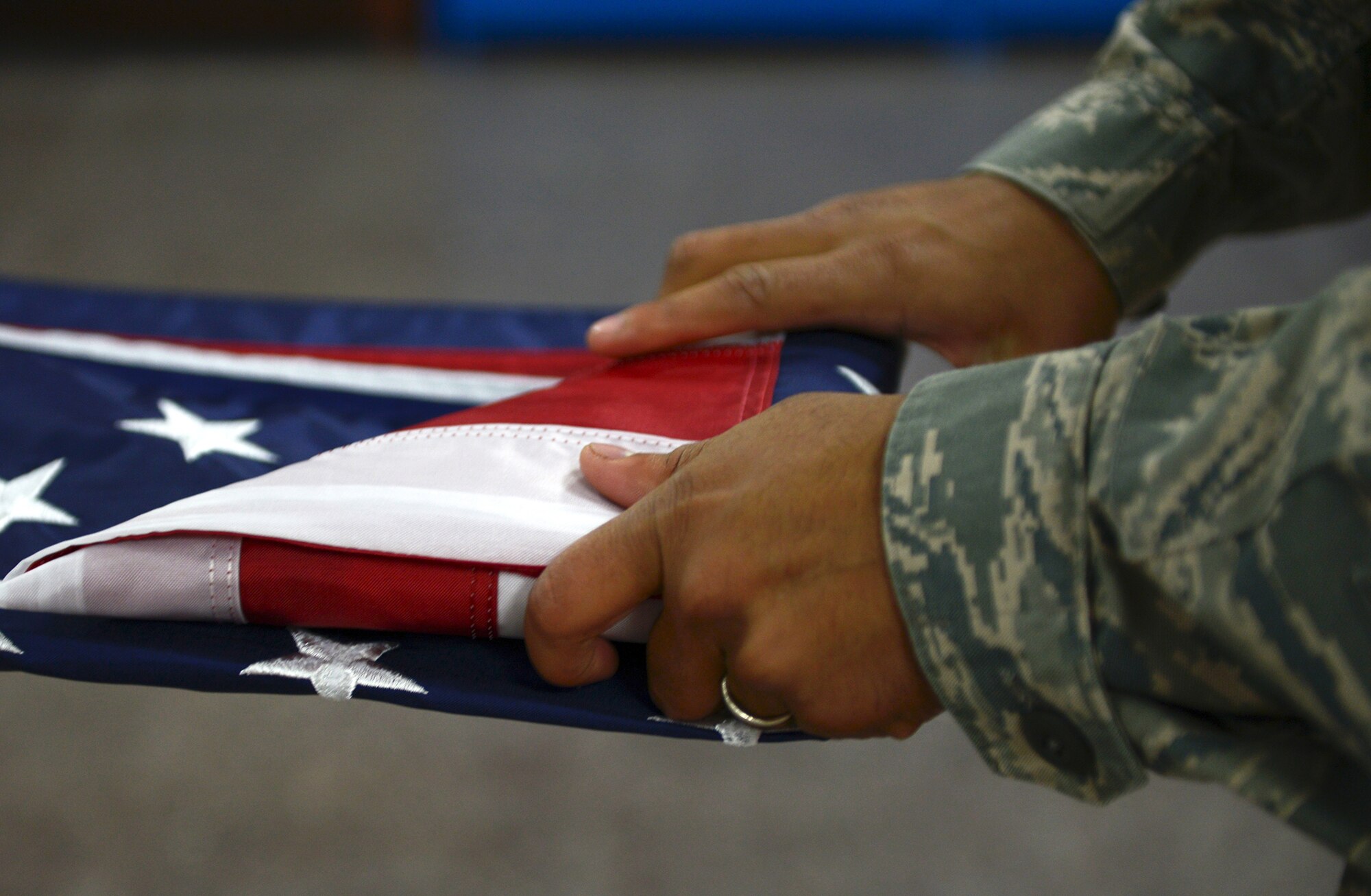 Senior Airman Ariful Haque, Yokota Air Base Honor Guard ceremonial guardsman, folds a United States flag at Yokota Air Base, Japan, Nov. 13, 2013. When not serving in the Honor Guard, Haque works with the 374th Civil Engineering Squadron water and fuel systems maintenance shop. (U.S. Air Force photo by Airman 1st Class David Danford/Released)