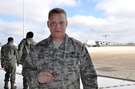 Staff Sgt. Brian Nelson, 433 Mainteance Squadron, shows off one thecommander's coin he found on the flightline during a wing-wide Foreign Object Damage Nov.17.  FOD can range from wires, screws and rocks. All can damage a plane's engine which in turn can delays a mission and cost the government money to repair the aircraft. (U.S. Air Force photo/Technical Sgt. Carlos J. Trevino)