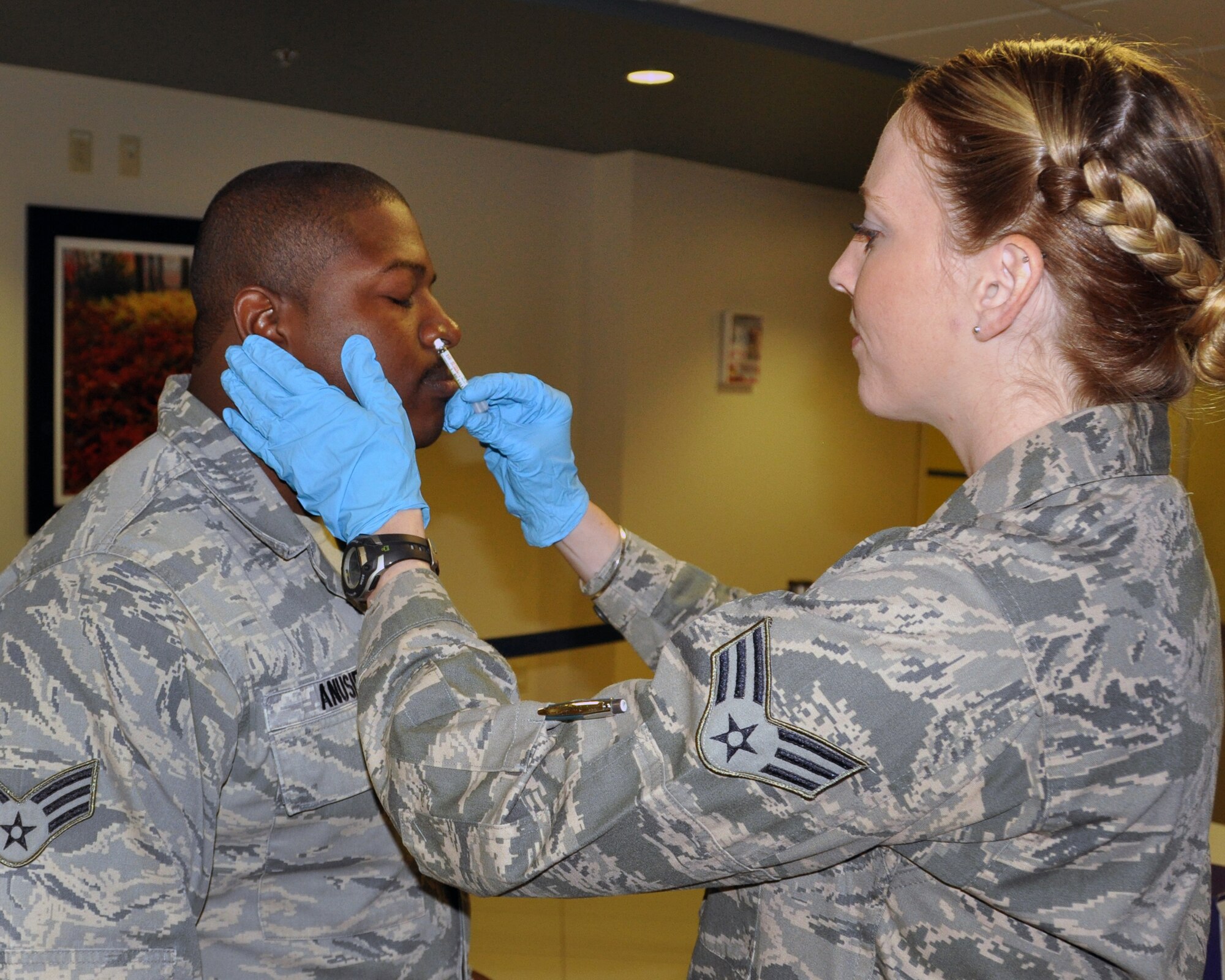 Senior Airman Emmanuel Anusie, 512th Aircraft Maintenance Squadron, inhales as Senior Airman Katherine Echem, 512th Aerospace Medicine Squadron, delivers the flu vaccine at the base clinic, Dover Air Force Base, Nov. 3, 2013. Over the course of the unit training assembly, 512th AMDS gave 833 flu shots to Liberty Wing airmen. (U.S. Air Force photo/Senior Airman Erika Brooke)