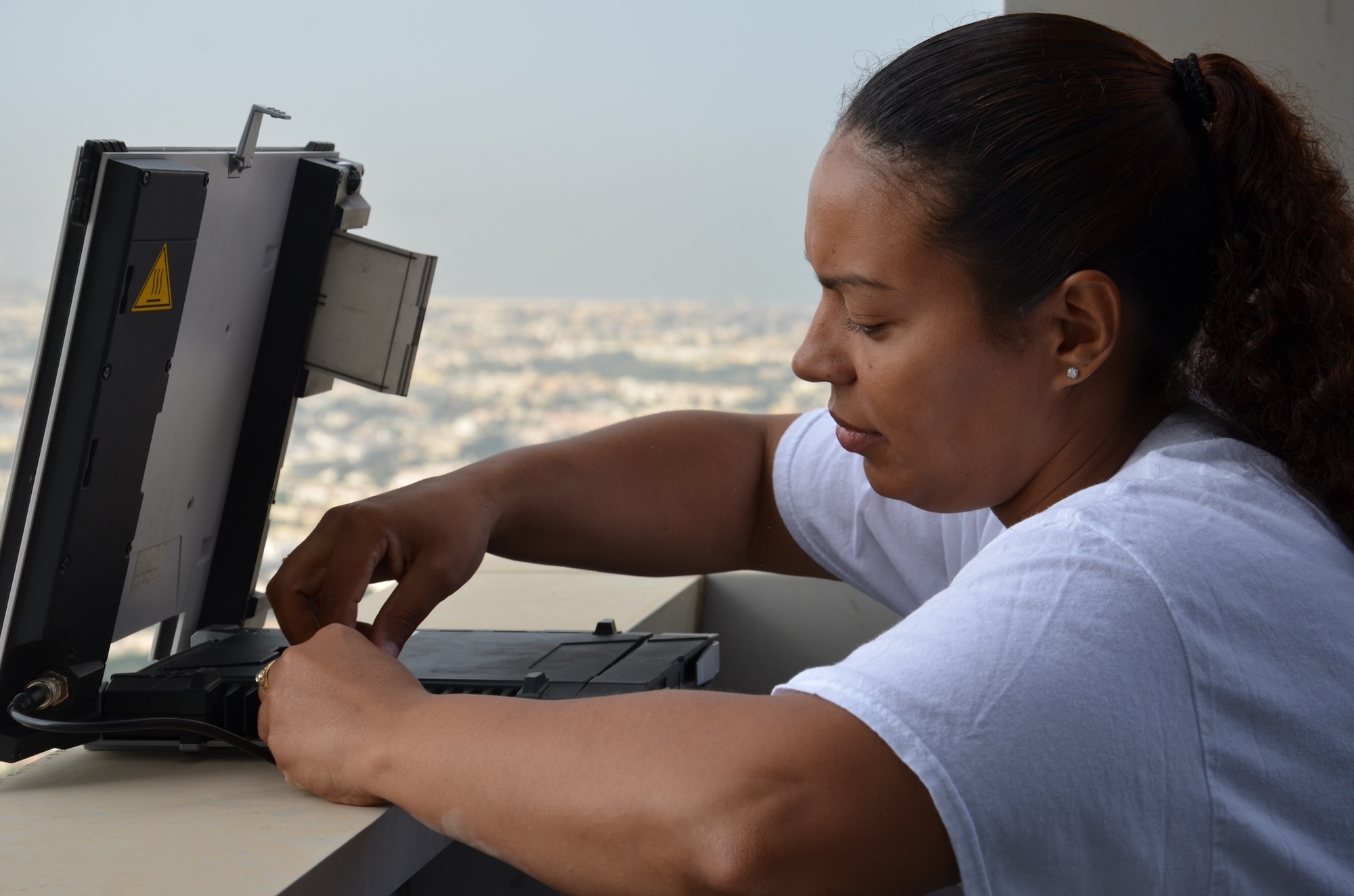 Tech. Sgt. Peggy Hockett lines up a modem to a satellite flying overhead, Nov. 15, 2013, which will provide secure and unsecured communications to American decision makers throughout the region at the Dubai World Central airport in Jebel Ali, United Arab Emirates. Hockett is a Radio Frequency Transmission Systems NCO in charge deployed from Tinker Air Force Base, Okla., and a graduate of Lewiston High School, Maine. (U.S. Air Force photo/Maj. David Faggard)