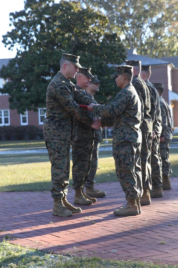 Navy Petty Officer 2nd Class Vichien Mixay, a hospital corpsman with 2nd Battalion, 9th Marine Regiment, 2nd Marine Division, from Jones, Mich., receives his award from Brig. Gen. Burke W. Whitman, the 2nd Marine Divison Assistant Division Commander during a morning colors and awards ceremony aboard Marine Corps Base Camp Lejeune, Nov. 14, 2013. Mixay was selected as the 2nd Marine Division Junior Sailor of the quarter for July 2013 through Sept. 2013.