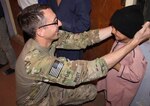 Soldiers of the 1103rd Military Police Detachment hand out coats, gloves, hats and candy to Afghan children at an orphanage in the Balkh Province, Afghanistan, Oct. 22, 2013.