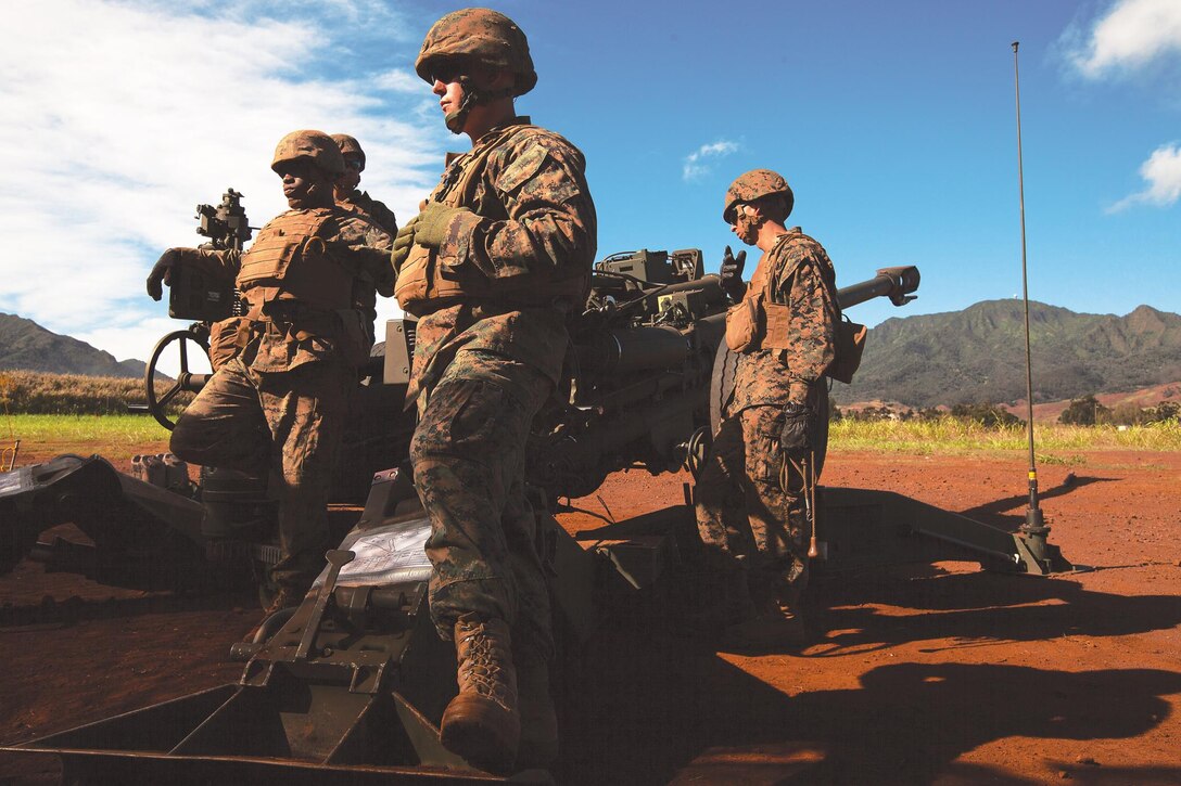 Marines with Bravo Battery, 1st Battalion, 12th Marine Regiment, wait for the call to fire an M777 howitzer during a dual-fire exercise at Schofield Barracks, Hawaii, Nov. 13, 2013. The dual-fire exercise included shooting M327 Towed-Rifled Mortar Systems alongside the M777s during the two-day training exercise. (U.S. Marine Corps photo by Lance Cpl. Matthew Bragg)