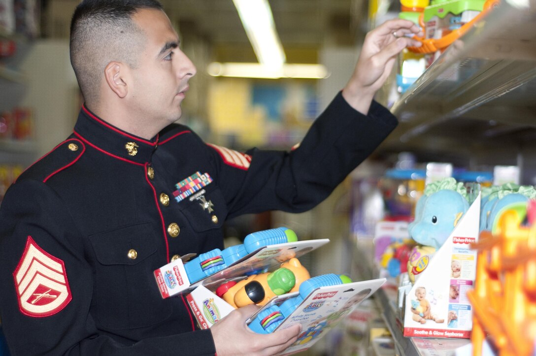 Then Staff Sgt. Rafael Arriaga Jr., Toys for Tots coordinator, 4th Force Reconnaissance Company, chooses several toys to buy at Toys ‘R’ Us, Dec. 1, 2010. Volunteers are accepting unwrapped toys and monetary donations during several events this year. (U.S. Marine Corps photo by Christine Cabalo)