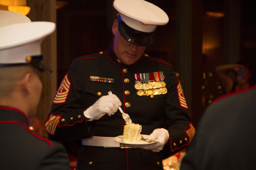 Master Gunnery Sgt. Bradley Chandler (ret.) accepts the second piece of cake as the oldest Marine during the birthday ball ceremony at the Waterfront Restaurant and Tavern, on November 15, 2013.  The birthday cake is passed from the oldest to the youngest Marine present, symbolizing the passing of history and traditions to the next generation.