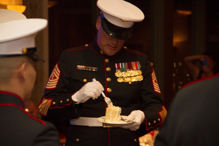 Master Gunnery Sgt. Bradley Chandler (ret.) accepts the second piece of cake as the oldest Marine during the birthday ball ceremony at the Waterfront Restaurant and Tavern, on November 15, 2013.  The birthday cake is passed from the oldest to the youngest Marine present, symbolizing the passing of history and traditions to the next generation.