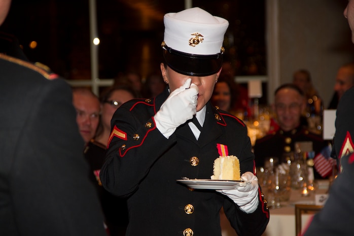 Pfc. Rylee Stocco tastes the second piece of cake as the youngest Marine present during the birthday ball ceremony at the Waterfront Restaurant and Tavern, on November 15, 2013.  The birthday cake is passed from the oldest to the youngest Marine present, symbolizing the passing of history and traditions to the next generation.