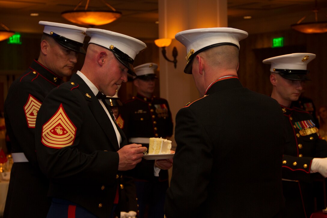 Maj. Charles D. Godwin, Recruiting Station Milwaukee Commanding Officer, presents the first piece of cake to the guest of honor, Sergeant Major of the Marine Corps Sgt. Maj. Micheal P. Barrett, during the birthday ball ceremony at the Waterfront Restaurant and Tavern, on November 15, 2013.  