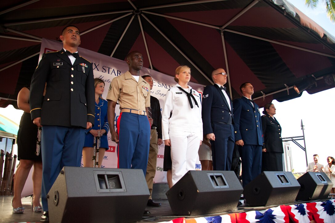 Army Spc. William Tosie of 8th Special Troop Battalion; Marine Cpl. Matthew Noah of 3rd. Marine Regiment; Navy Petty Officer 3rd Class Nicole Woodall of Pacific Command Joint Intelligence Operation Center, Pearl Harbor; Senior Airman William Bradford of the 15th Wing, Hickam AFB; Coast Guard Petty Officer 2nd Class Erich Klingner of Engineering Division, Air Station Barbers Point; Hawaii National Guardswoman Sgt. Andrea Faoa of 29th Infantry Brigade Combat Team stand on stage while being recognized during the USO Hawaii Six Star Service Salute, Nov. 2, 2013. (U.S. Marine Corps photo by Cpl. Nathan Knapke)