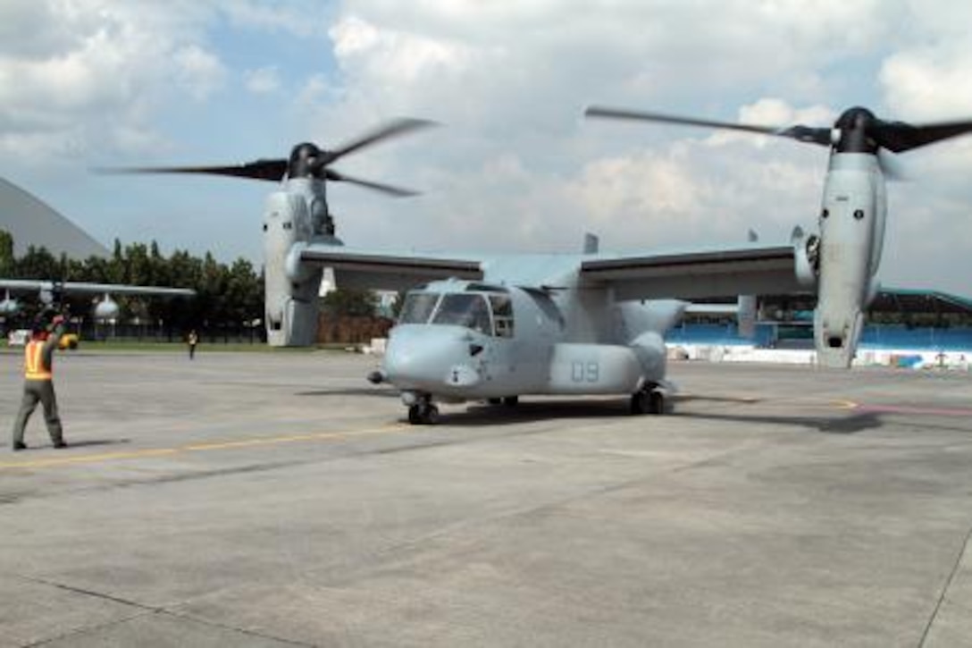 Philippine Air Force Sgt. Bobby Elpedes, a landing support specialist with the 520th Air Base Wing, signals to stop to the pilot of an MV-22B Osprey during Operation Damayan at Villamor Air Base Nov. 14. U.S Marines arrived at Villamor Air Base Nov. 10 to help assist the Philippine government in humanitarian aid and disaster relief efforts. The Osprey provides a unique capability in this type of operation due to its vertical takeoff and landing capabilities and its ability to convert quickly to fixed wing configuration, giving it increased speed and range.