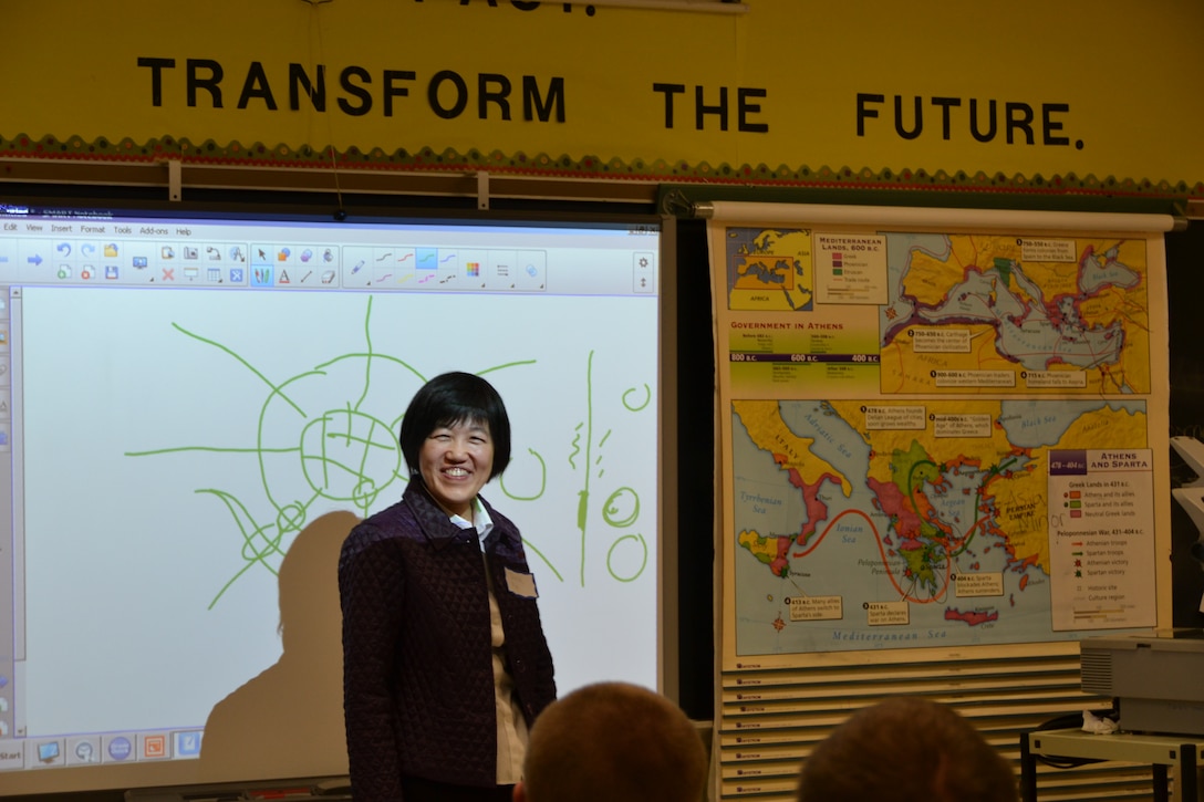 Civil Engineer Qing Xu illustrates a point by drawing a city layout and roads that come into it with students at the James Wood High School Career Fair, Nov. 13.