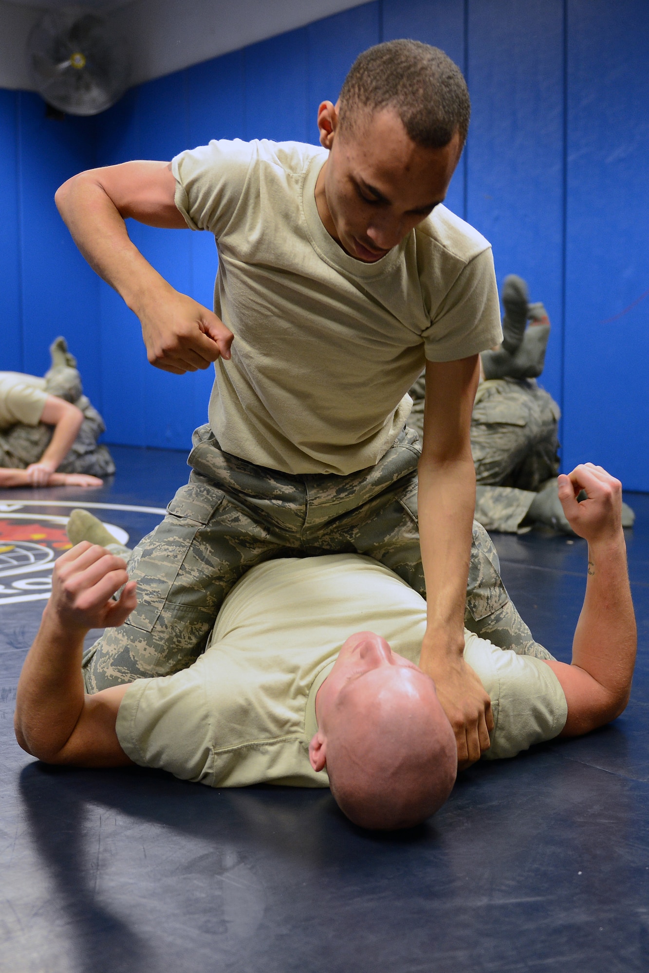 Senior Airman Joseph Timpson, 10th Airlift Squadron loadmaster, pins Senior Airman Sully Luepke, 62nd Maintenance Group scheduler, to the ground during a self-defense course Nov. 14, 2013, at Joint Base Lewis-McChord, Wash. Through the course, members of the 627th Security Forces Squadron taught the students taught how to respond, deflect and evade various attack scenarios. (U. S. Air Force photo/Airman 1st Class Jacob Jimenez)