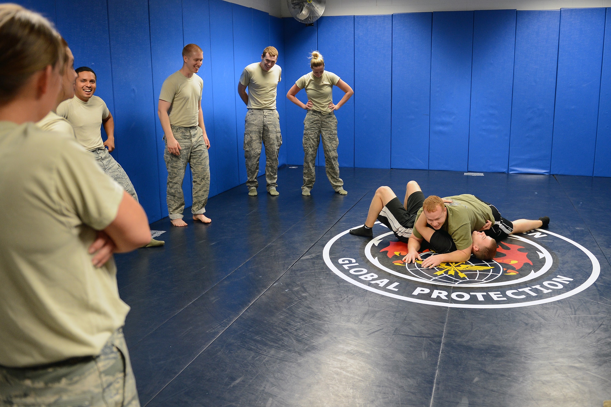 Staff Sgt. Wade Owen 627th Security Forces Squadron, Phoenix Ravens scheduler, demonstrates a ground grappling body positioning move to Airmen participating in self-defense course, Nov. 14, 2013, at Joint Base Lewis-McChord, Wash. 627th SFS Airmen provided the training for Airmen from the McChord Field 5/6 Club and Rising Four Airmen’s Council to educate them in basic self-defense skills. (U. S. Air Force photo/Airman 1st Class Jacob Jimenez)