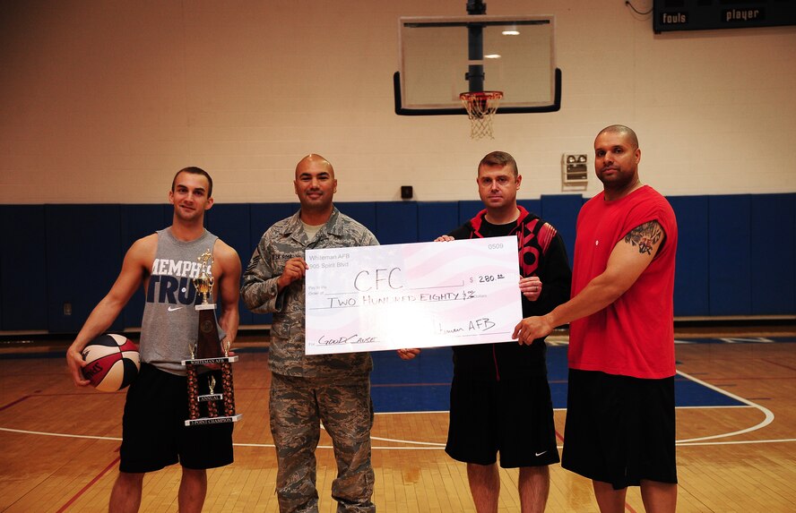 Jonathan Elder, far left, 509th Security Forces Squadron, poses after winning  the Combined Federal Campaign (CFC) three-point shoot-out Nov. 8, 2013, at Whiteman Air Force Base, Mo. The event raised $280 for the CFC. Also pictured are Master Sgt. John De La Rosa, Whiteman CFC representative, and Master Sgt. Charles Yates and Tech. Sgt. Damian Bunch from the 509th Operations Support Squadron. (U.S. Air Force photo by Staff Sgt. Brigitte N. Brantley/Released)