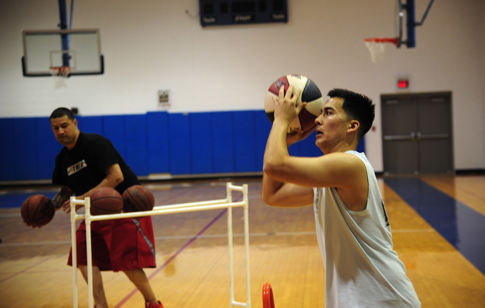 Matthew Ford, right, from the 509th Operations Support Squadron, takes a shot during the Combined Federal Campaign (CFC) three-point shoot-out Nov. 8, 2013, at Whiteman Air Force Base, Mo. About 20 people participated in the event, which raised more $280 for the CFC. (U.S. Air Force photo by Staff Sgt. Brigitte N. Brantley/Released)