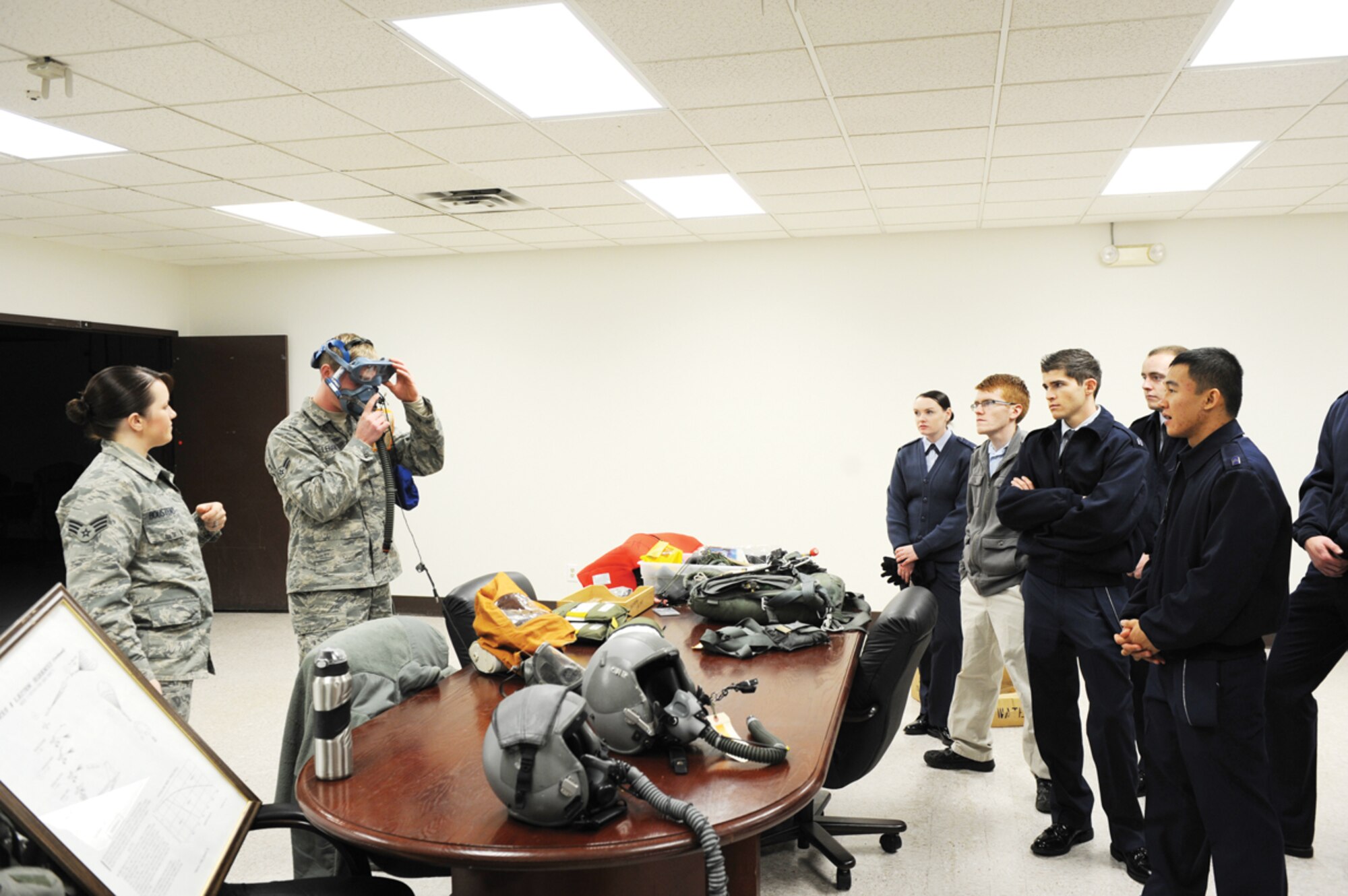 Airman 1st Class Dillon Lebahn, member of the 3rd Operations Support Squadron, shows Air Force Reserve Officer Training Corps cadets from the University of Anchorage Alaska how to don a one-handed emergency breathing mask at the Air Crew Flight equipment facility Nov. 8. UAA ROTC cadets visit JBER to get an idea of what it’s like to be in the military. (U.S. Air Force photo/Airman 1st Class Omari Bernard)