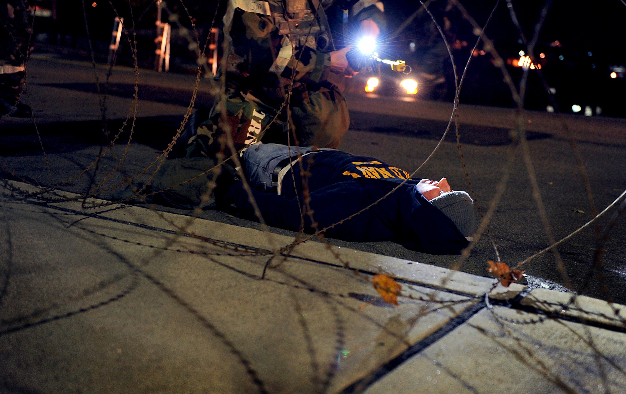 An Airman from the 51st Security Forces Squadron examines a simulated opposition forces member casualty during Operational Readiness Exercise Beverly Bulldog 14-01 at Osan Air Base, Republic of Korea, Nov. 19, 2013. This scenario was one of many that 51st SFS Airmen will encounter during the ORE as they train to deter foreign aggression and defend the base. (U.S. Air Force photo/Staff Sgt. Sara Csurilla)