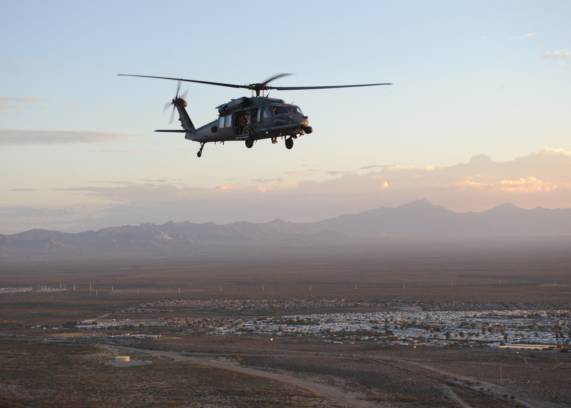 An HH-60 Pavehawk from the 55th Rescue Squadron at Davis-Monthan Air Force Base, Ariz., flies over Tucson, Nov. 13, 2013, during alternate insertion and extraction training with the pararescuemen of the 48th Rescue Squadron.  (U.S. Air Force photo by 1st Lt Sarah Ruckriegle/released) 