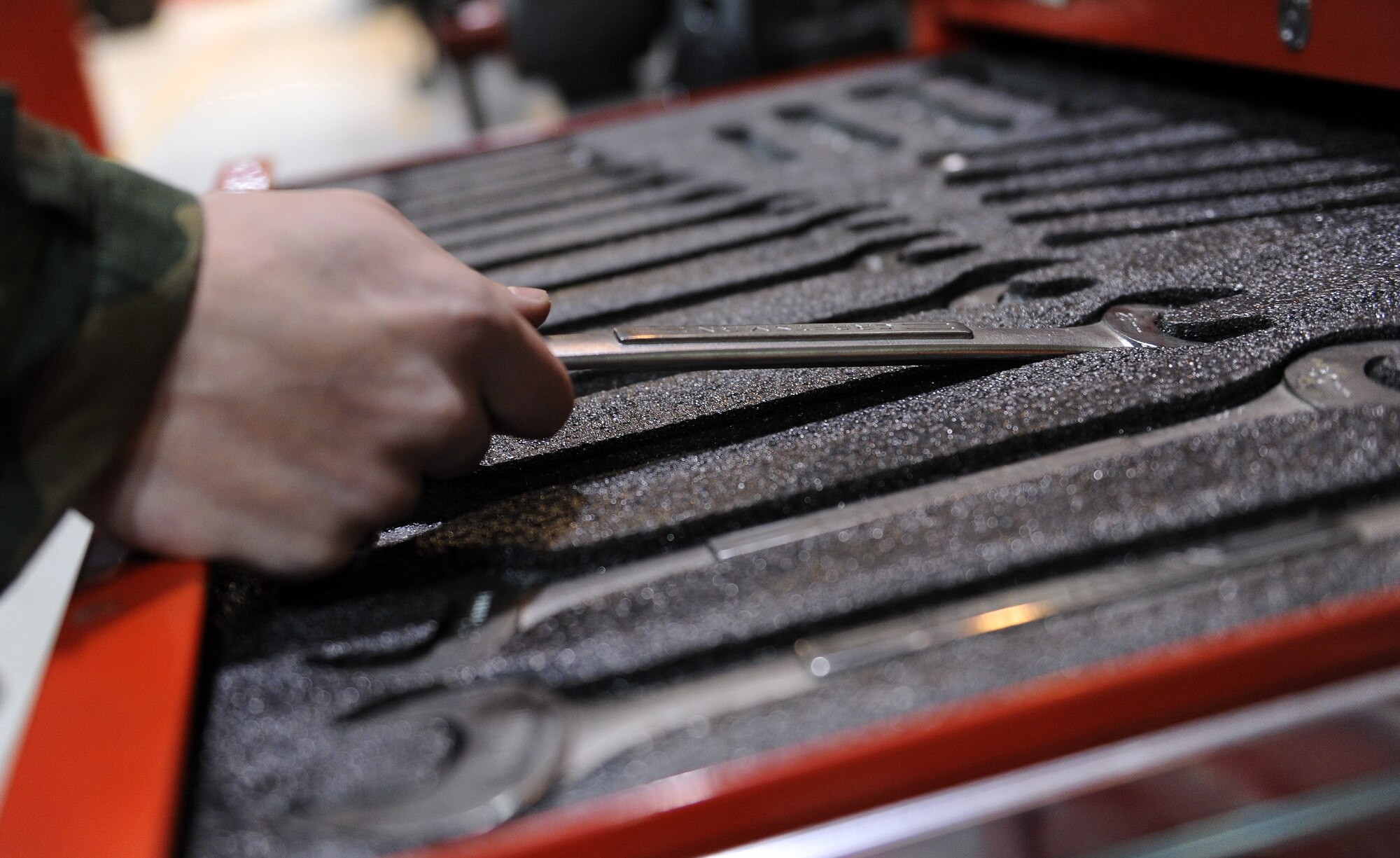 Senior Airman Joshua Ghiloni, 51st Logistics Readiness Squadron vehicle maintenance technician, chooses a wrench from a selection of tools to service a vehicle ring during Operational Readiness Exercise Beverly Bulldog 14-01 at Osan Air Base, Republic of Korea, Nov. 19, 2013. Osan Airmen are in the fifth simulated wartime contingency operation executed in 2013 that will test the base's ability to defend and execute its mission in a heightened state of readiness. (U.S. Air Force photo/Staff Sgt. Sara Csurilla)
