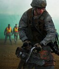 Airman 1st Class Patrick Wagenecht, 91st Security Support Squadron tactical response force member simulates using an electric saw during a recapture, recovery exercise, Nov. 14, 2013. The exercise is used as a training tool to evaluate the responding forces, their reaction of denying access to the resource from hostile actions, and recovery of the resource if access is gained. (U.S. Air Force photo/Senior Airman Brittany Y. Auld)