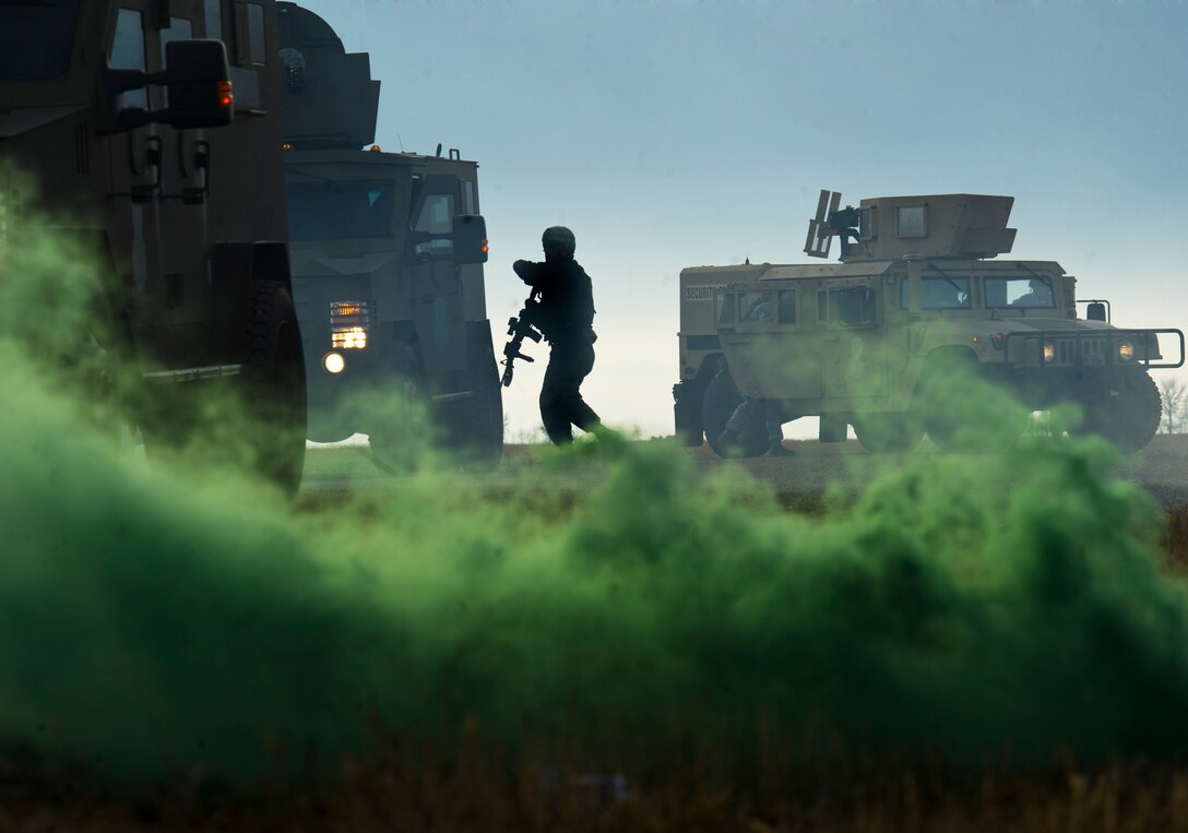 Members of the 791st Missile Security Force Squadron convoy response force rush out of their Bearcats during a recapture, recovery exercise, Nov. 14, 2013. The exercise is used as a training tool to evaluate the responding forces, their reaction of denying access to the resource from hostile actions, and recovery of the resource if access is gained. (U.S. Air Force photo/Senior Airman Brittany Y. Auld)