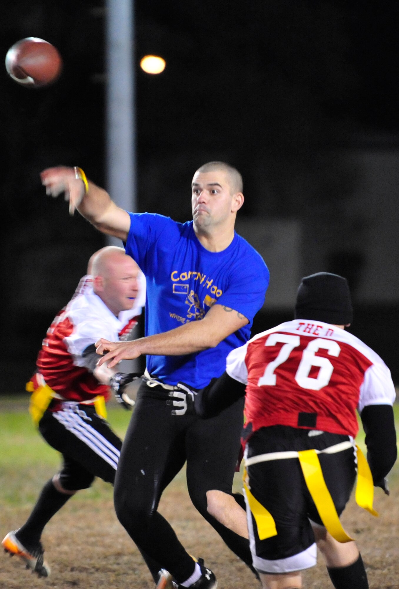 Cid Fernandez, 9th Airlift Squadron quarterback, throws a touchdown pass while the 436th Medical Group applies pressure during a flag football game Nov. 14, 2013, at Dover Air Force Base, Del. Fernandez threw for four touchdowns and rushed for one, leading his team past the 436th MDG 32-12. (U.S. Air Force photo/Airman 1st Class William Johnson)
