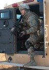 Senior Airman Paul Olmos, 91st Security Support Squadron tactical response force member, prepares to position himself in the necessary location to protect the convoy’s assets during an exercise, Nov. 14, 2013. The exercise is used as a training tool to evaluate the responding forces, their reaction of denying access to the resource from hostile actions, and recovery of the resource if access is gained. (U.S. Air Force photo/Airman 1st Class Apryl Hall)