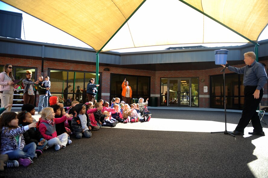 Greg Allen, The Magic of Recycling presenter, performs a recycling bin magic trick with children at the Child Development Center II, Moody Air Force Base, Ga., Nov. 14, 2013. Allen hopes that the more fun he makes learning about recycling, the more children will remember it and apply it to their lives. (U.S. Air Force photo by Senior Airman Olivia Bumpers/Released)