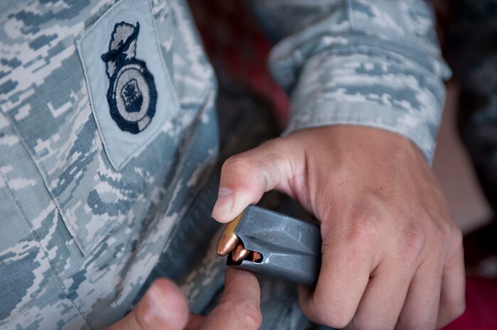 U.S. Air Force Senior Airman Jesse Frank, 99th Security Forces Squadron military working dog handler, loads ammunition into a magazine before the start of an exercise Nov. 15, 2013, at Nellis Air Force Base, Nev. MWD handlers are recruited from within the security forces career field, then attend training at Joint Base San Antonio, Texas. (U.S. Air Force photo by Airman 1st Class Joshua Kleinholz)