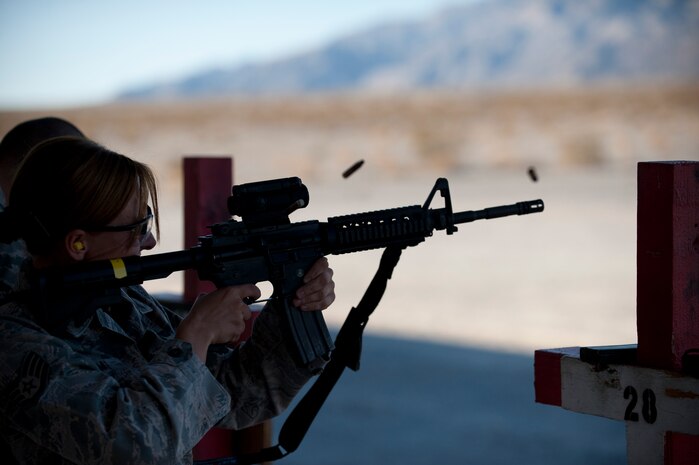 U.S. Air Force Staff Sgt. Bobbie Ohm, 99th Security Forces Squadron military working dog handler, fires an M-4 Carbine downrange Nov. 15, 2013, at Nellis Air Force Base, Nev. The M-4 Carbine is a gas-operated, magazine-fed, selective fired, shoulder-fired weapon with a telescoping stock and 14.5 inch barrel. (U.S. Air Force photo by Airman 1st Class Joshua Kleinholz)