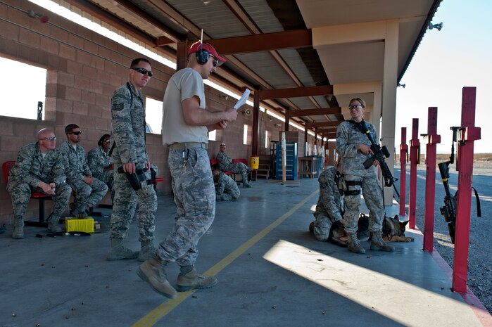 Military working dog handlers from the 99th Security Forces Squadron conduct a military working dog Course of Fire exercise at the firing range Nov. 15, 2013, at Nellis Air Force Base, Nev. This MWD course will be conducted twice a year as an ongoing training program. (U.S. Air Force photo by Senior Airman Matthew Lancaster)