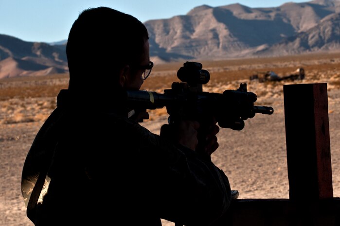 U.S. Air Force Staff Sgt. Matthew Lenegen, 99th Security Forces Squadron military working dog handler, fires an M4 Carbine assault rifle during a military working dog Course of Fire exercise at the firing range Nov. 15, 2013, at Nellis Air Force Base, Nev. During the training, the handler fired with an M4 Carbine and M9 Beretta at various firing positions with their MWD nearby. (U.S. Air Force photo by Senior Airman Matthew Lancaster)